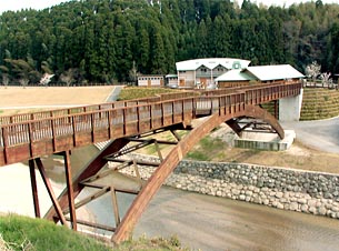 木製の若園橋、後方の建物はカヌー館