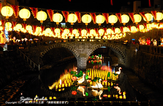 黄色いランタン（中国提灯）が飾られている眼鏡橋。川に浮かべる新型オブジェが今年（2010年）から初登場