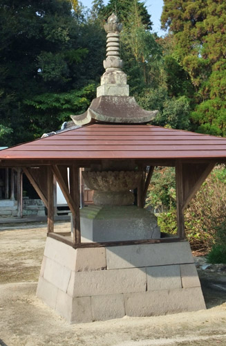 一部に屋根の付いた相輪屋頂式石造宝塔。４面に梵字が彫られており、建立年代は不明だが江戸時代と推測されています