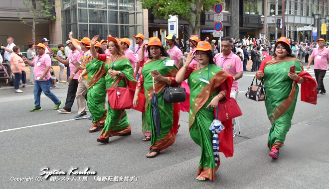 これはどこの国か？ サリーでオレンジの帽子はバングラデシュ(BANGLADESH) だ。　 サリーはインド・ネパール・スリランカ・バングラデシュ・パキスタンなど南アジア地域の女性