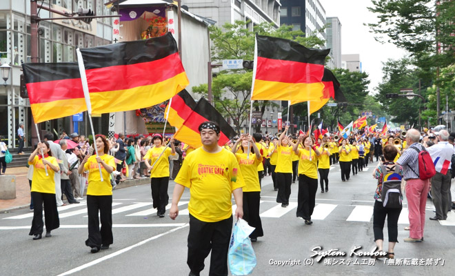 国旗はドイツだが、旗を持っているのは日本人　福岡マーチングバンド“QUATRE GATS”