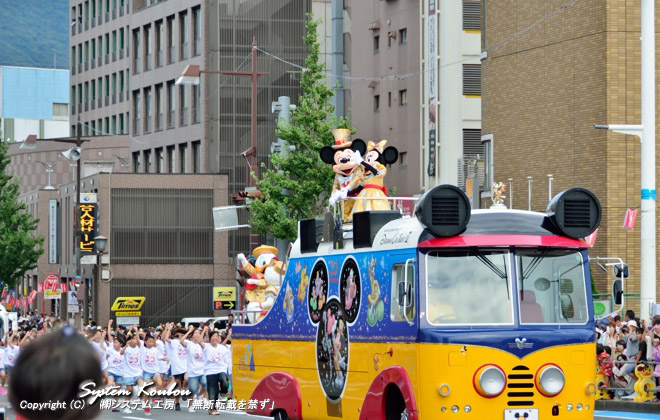 ドリームクルーザー�U（ディズニーバス）の上から沿道に手を振るミニーマウスと見つめるミッキーマウス