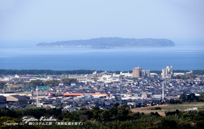 オレンジ色の横線の建物はグッデイ古賀千鳥店、後方の島は相ノ島